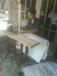 Yanti sedang menjahit tenda